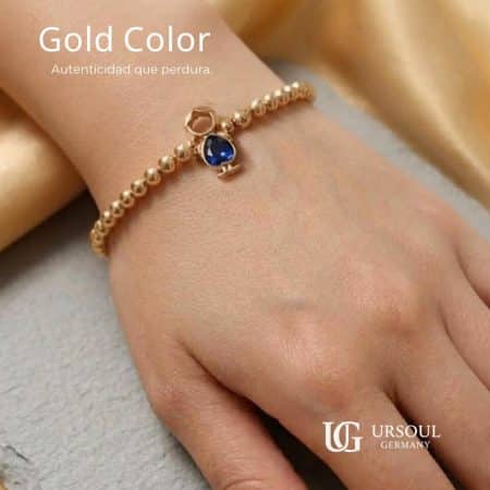 Pulsera para dama Gold Color con figura de niño y cristal azul de Ursoul Germany