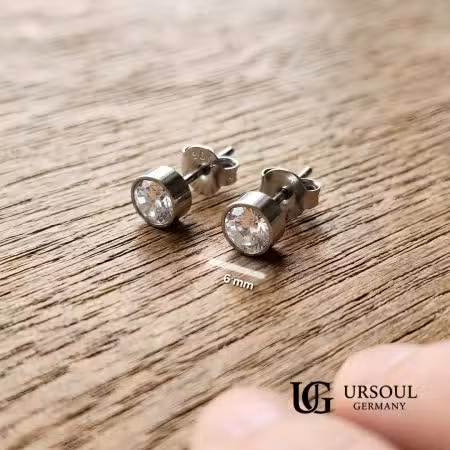Par de aretes solitario con cristal 6mm plateados para hombre, Silver Plated Ursoul Germany, sobre superficie de madera rústica