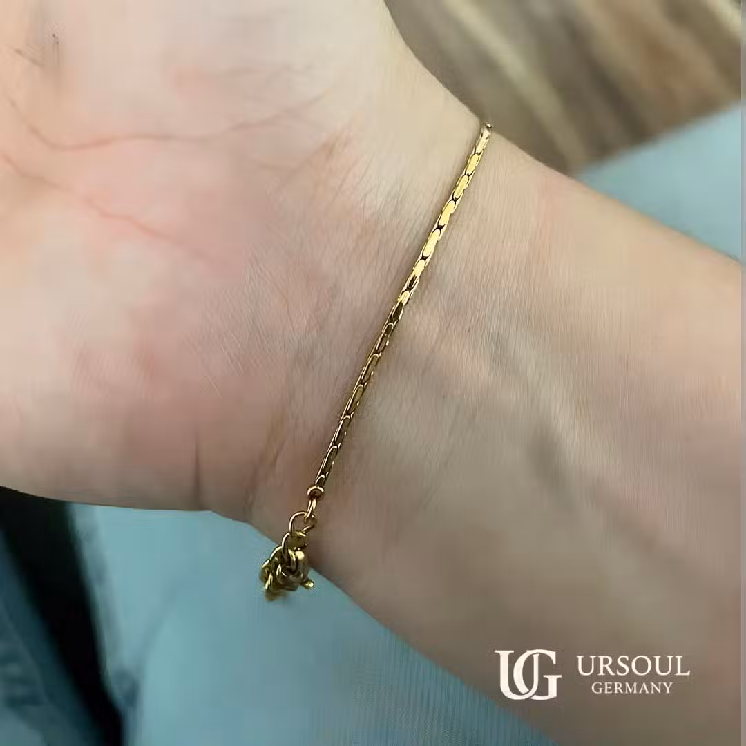 WhatsApp Image 2026-08-15 at 9.52.39 AM (2) Esclava eslabón plano dorada fina para hombre, Gold Color Ursoul Germany, sobre muñeca con fondo azul claro