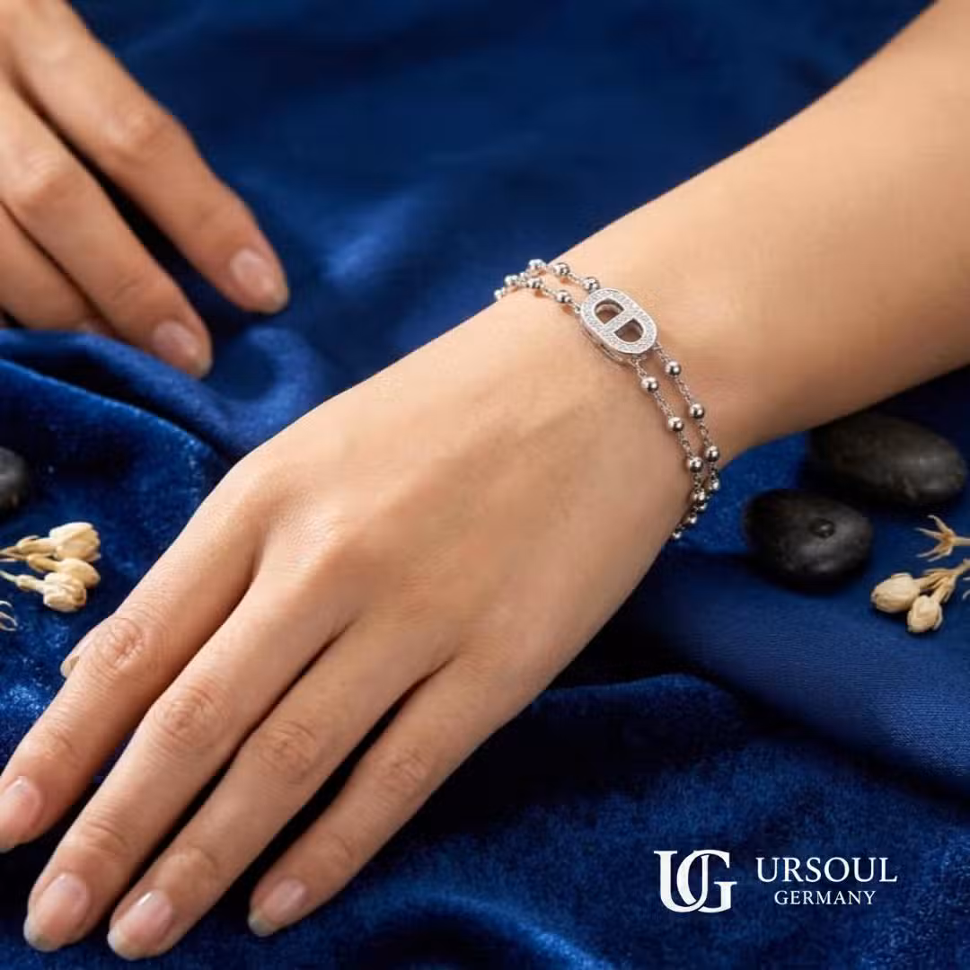 WhatsApp Image 2026-09-13 at 1.34.38 PM Pulsera doble cadena esferas plateada con eslabón marino de cristales para mujer, Silver Plated Ursoul Germany, sobre tela azul marino con piedras y flores secas