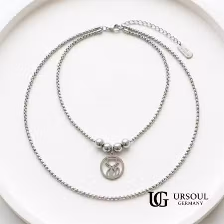 Collar doble cadena box plateada con esferas y dije gato calado para mujer, Silver Plated Ursoul Germany, sobre plato blanco y en cuello con camisa negra